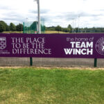 2022 Winchester University Sports Stadium purple and white ACM banner on fence