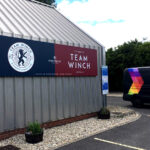 2022 Winchester University Sports Stadium navy and maroon sign tray on metal clad building